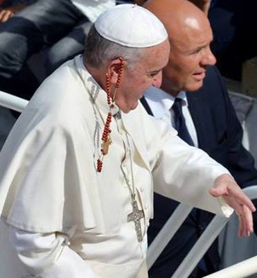 Освященный предмет (четки розария) на ушах преемника Петра